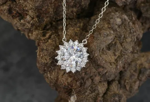 Diamond pendant with silver chain on rock