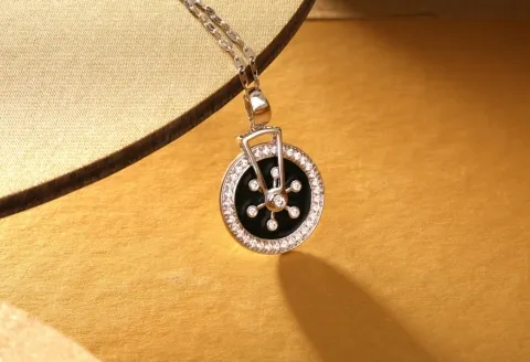 Silver and diamond pendant on golden backdrop