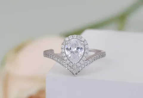 Close-up of a silver ring with a diamond placed on a surface