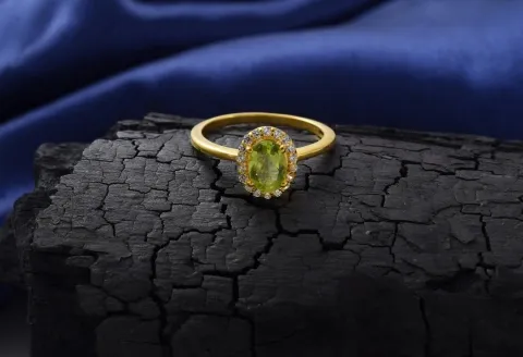 Golden engagement ring featuring green stone