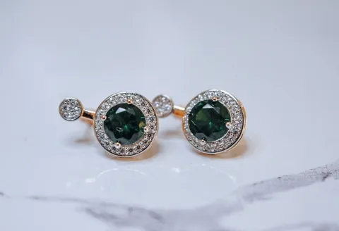 Close-up of rose gold diamond earring with gemstone