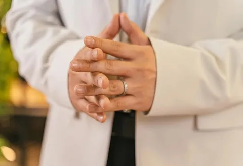 Man in white suit wearing men's wedding band