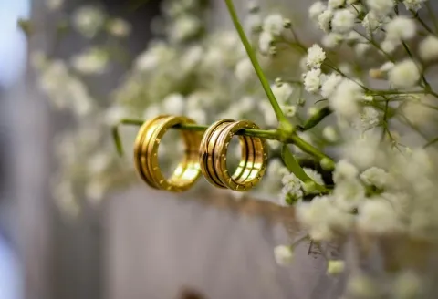 Gold men's wedding band on flowers