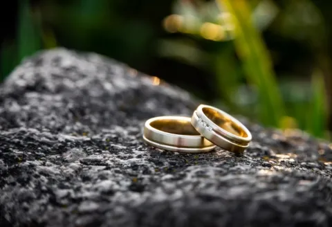 Gold men's wedding band on rock