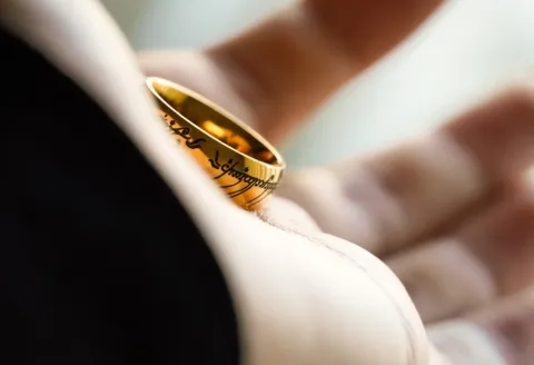 Groom holding a gold wedding band