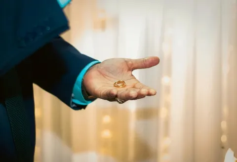 Man holding men's wedding band indoors