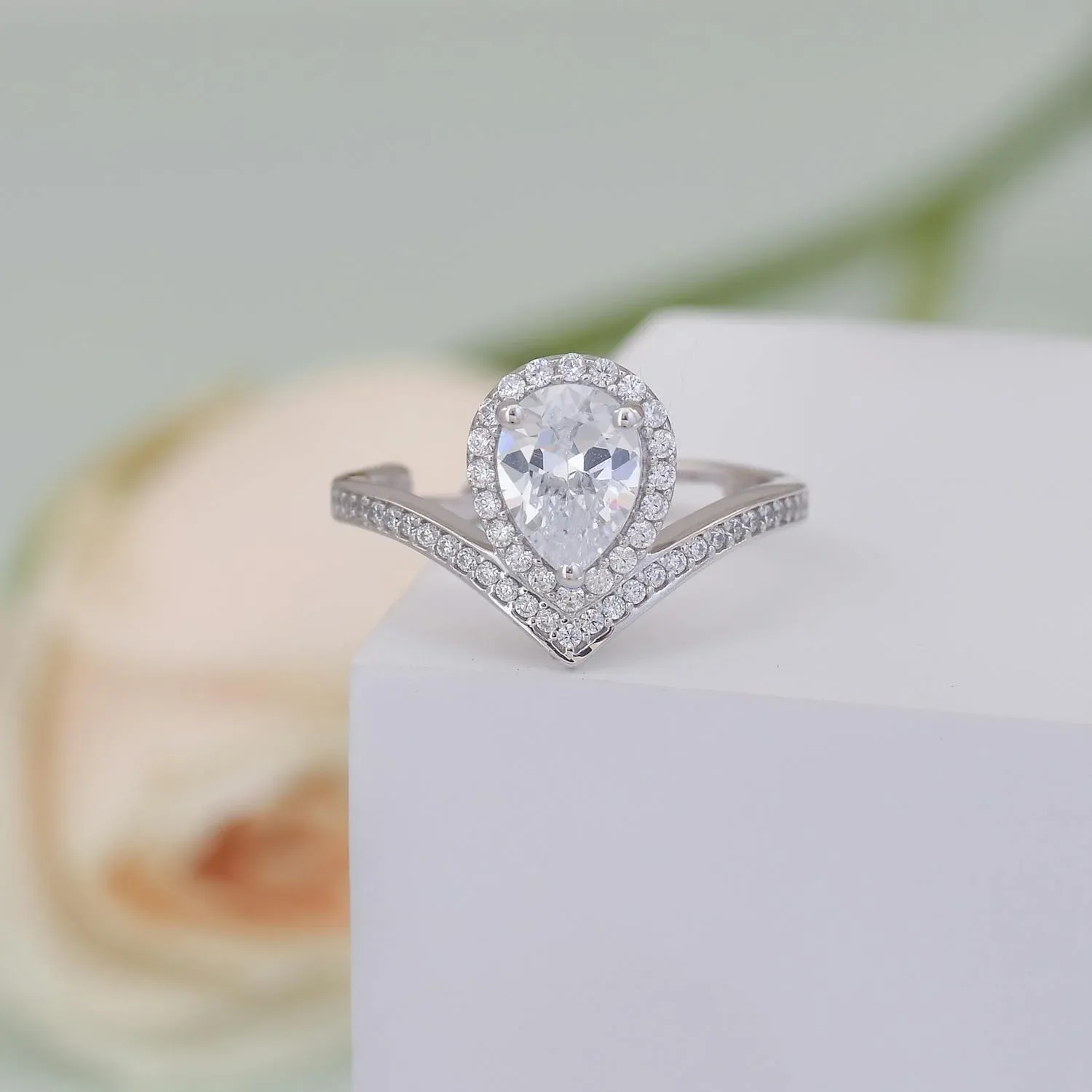 Pear-shaped custom engagement ring with diamonds.