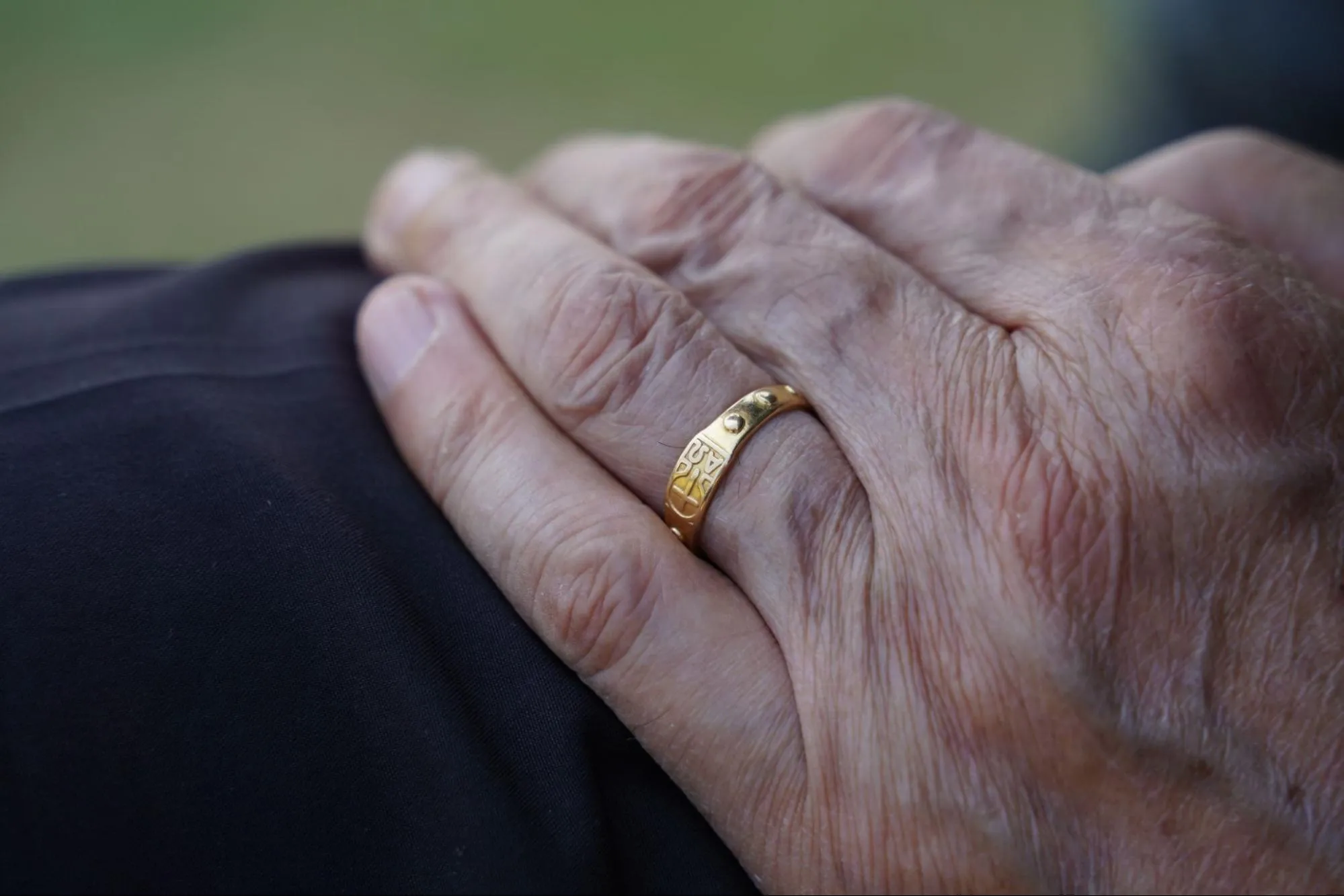 Elderly hand with classic gold men's wedding band