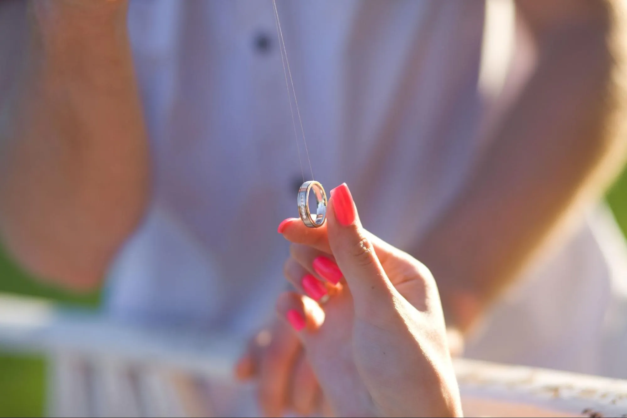 Silver modern men's wedding band held by woman
