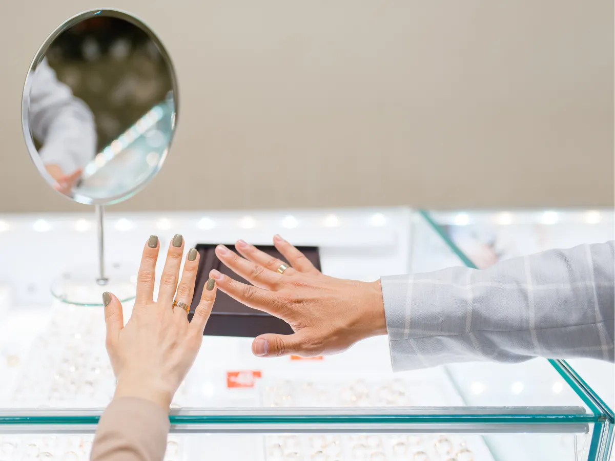 Couple's hands wearing wedding rings in store