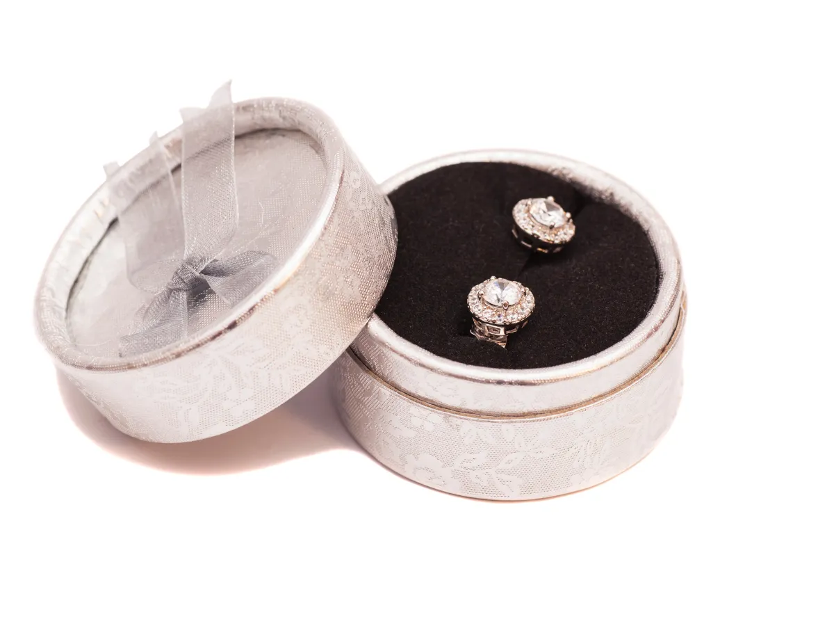 Diamond earrings placed in round jewelry box
