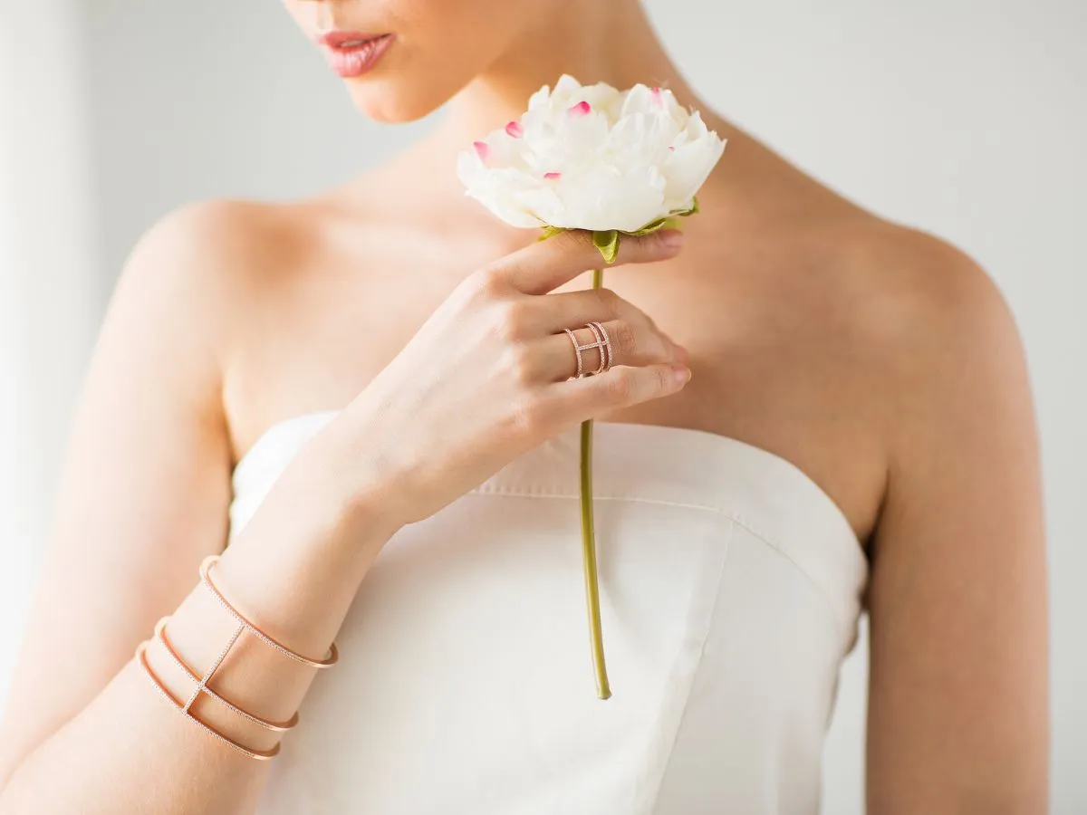 Woman holding flower, rose gold rings