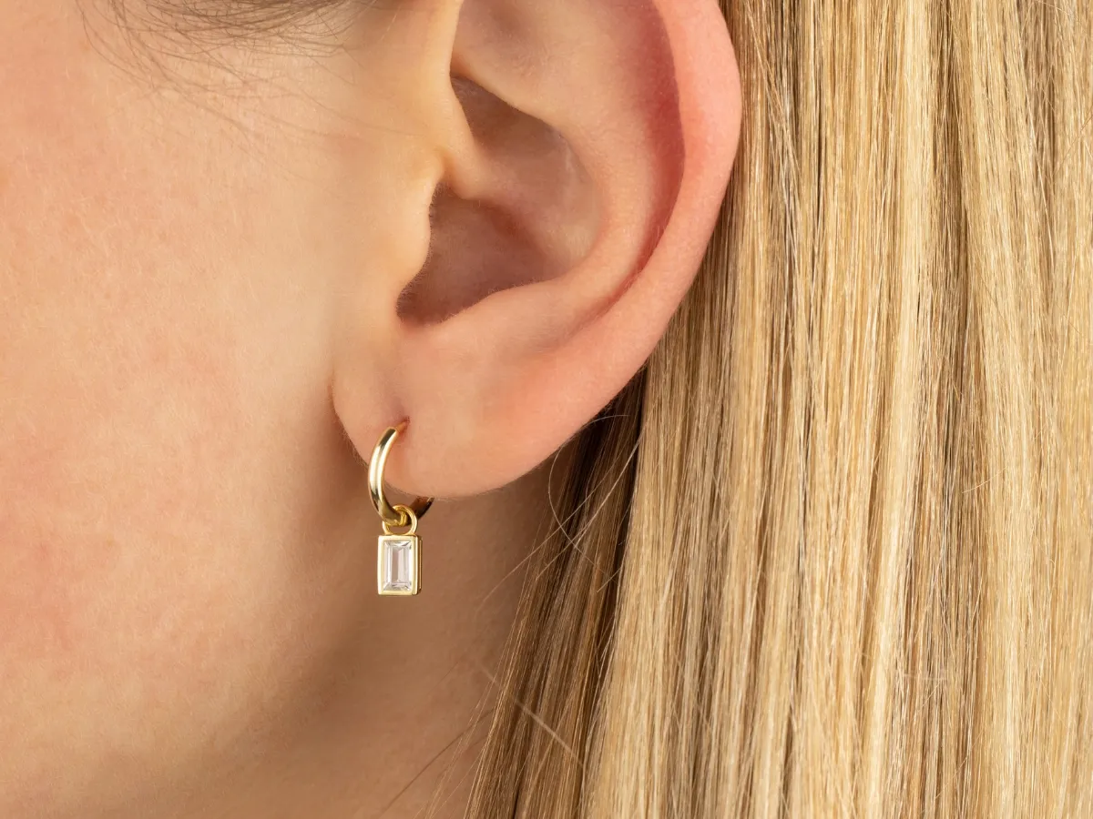 Gold hoop earring with baguette charm