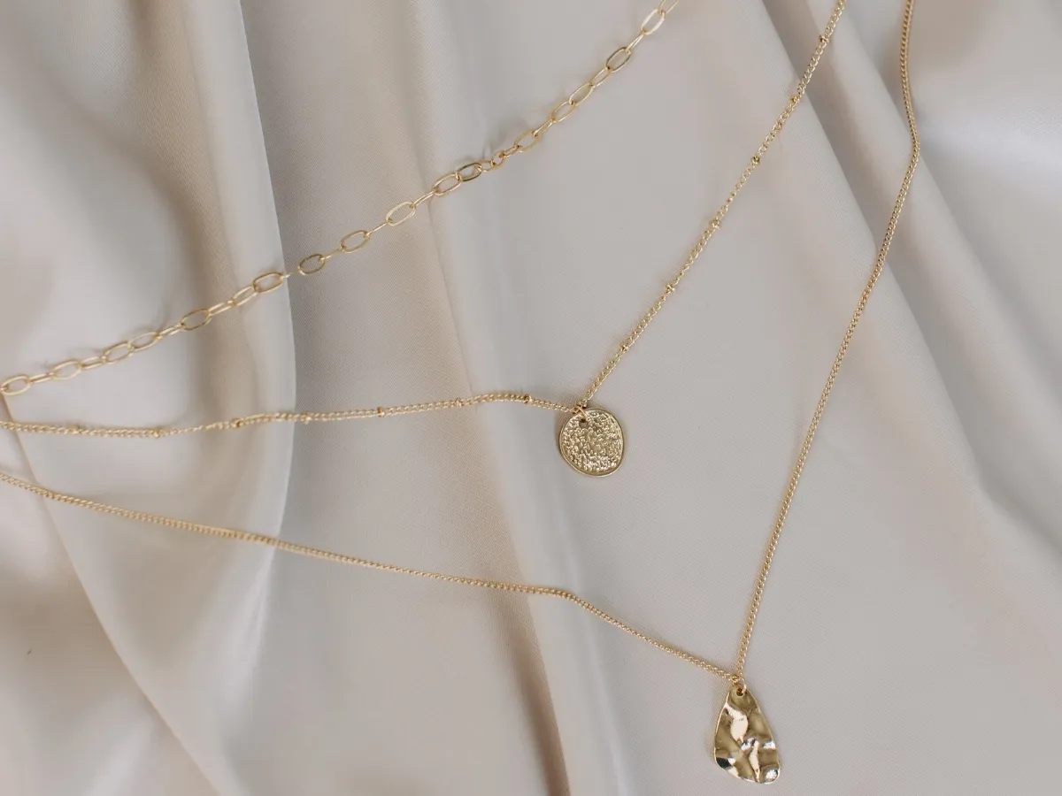 Layered gold necklaces on fabric