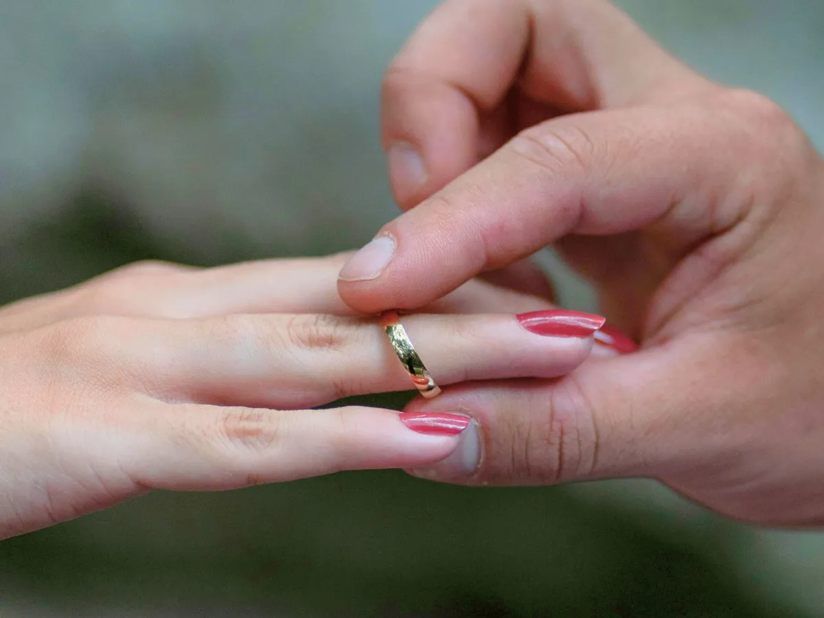 Man placing gold ring on finger