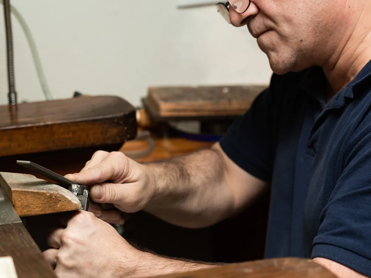 Jeweler filing textured metal ring design