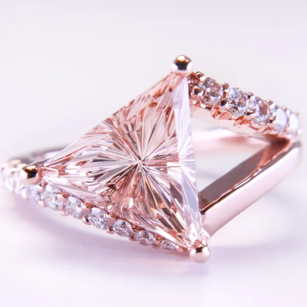 Custom rose gold ring with a pink trillion-cut gemstone and pave diamond band