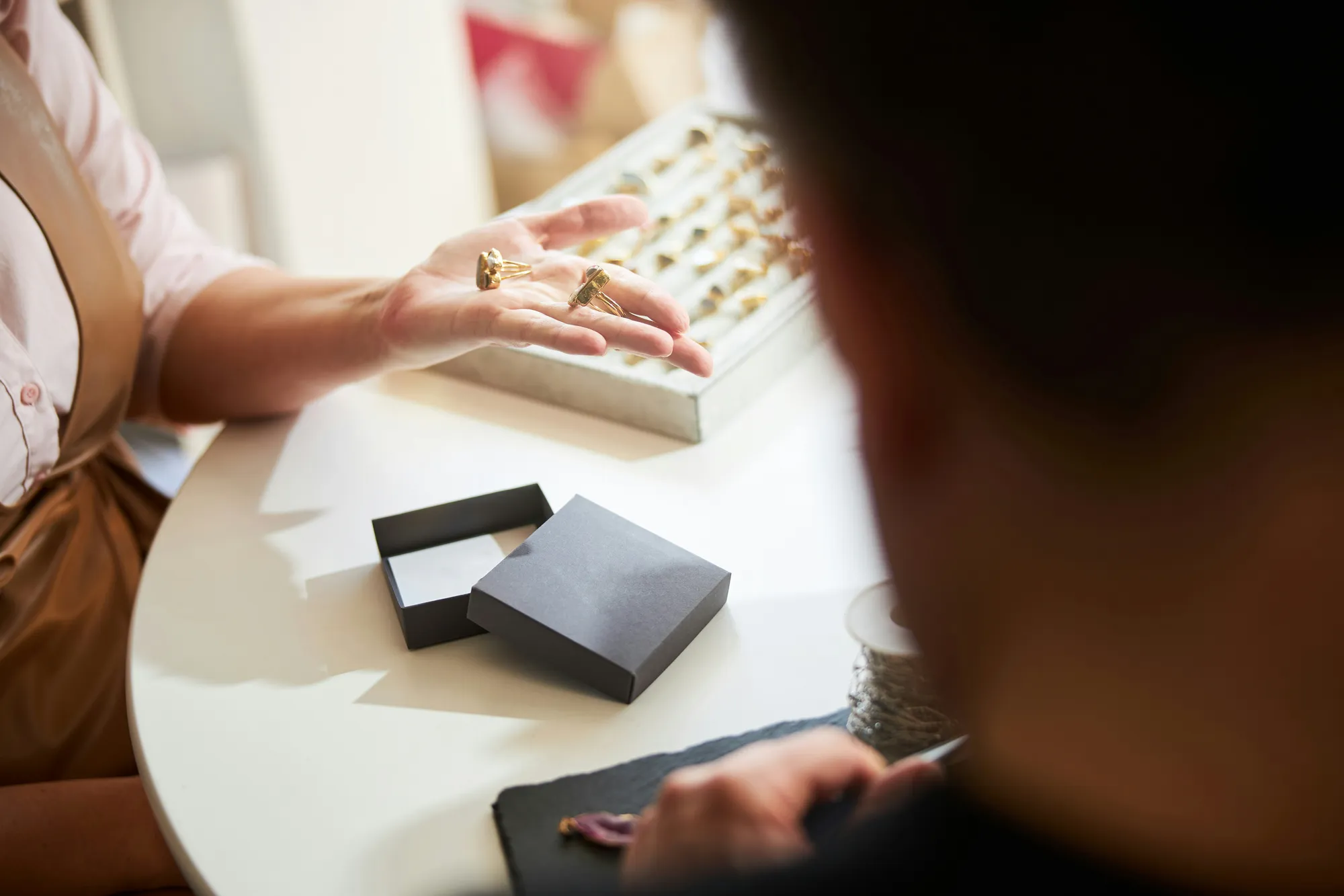 A client reviewing gold jewelry with a jeweler at the counter