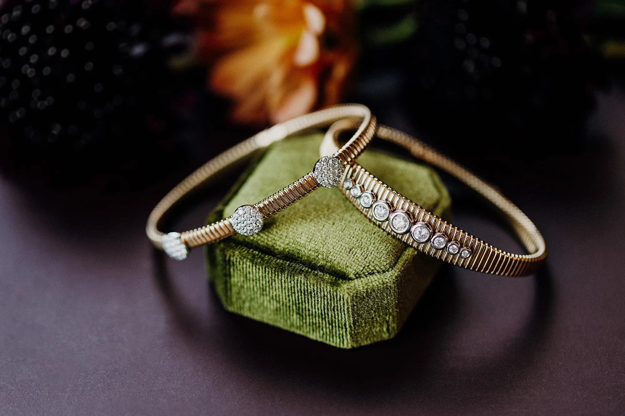 Two elegant Vahan Silver and 14K gold bracelets with pink and gold accents displayed on a velvet box against a pink background.