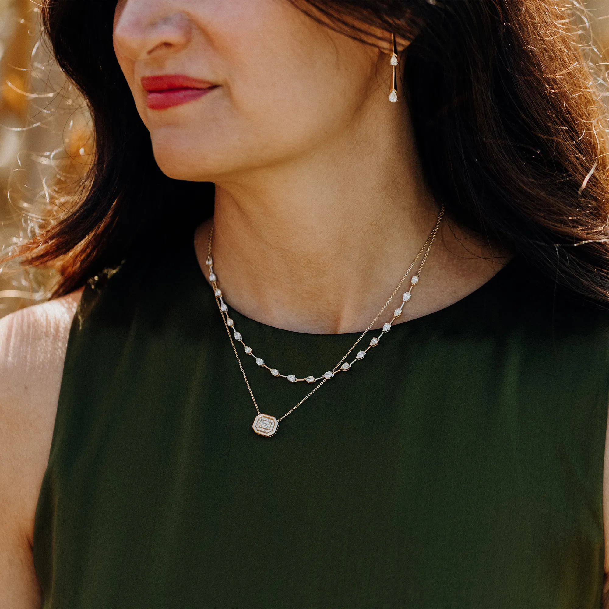 A woman in a floral dress holds a bouquet, showcasing diamond rings and a bracelet.