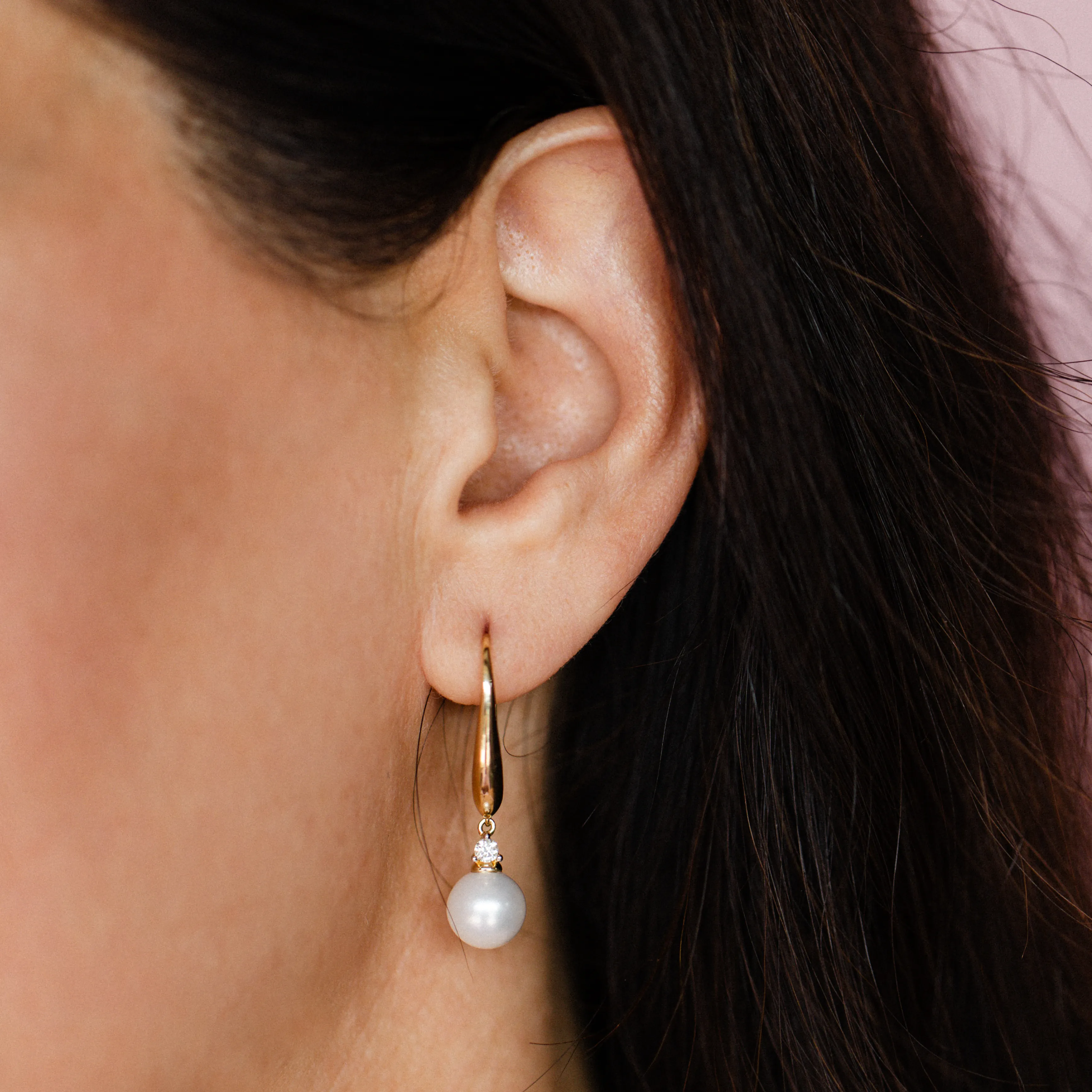 Gold earring with pearl and diamond on ear. Click to view estate earrings.
