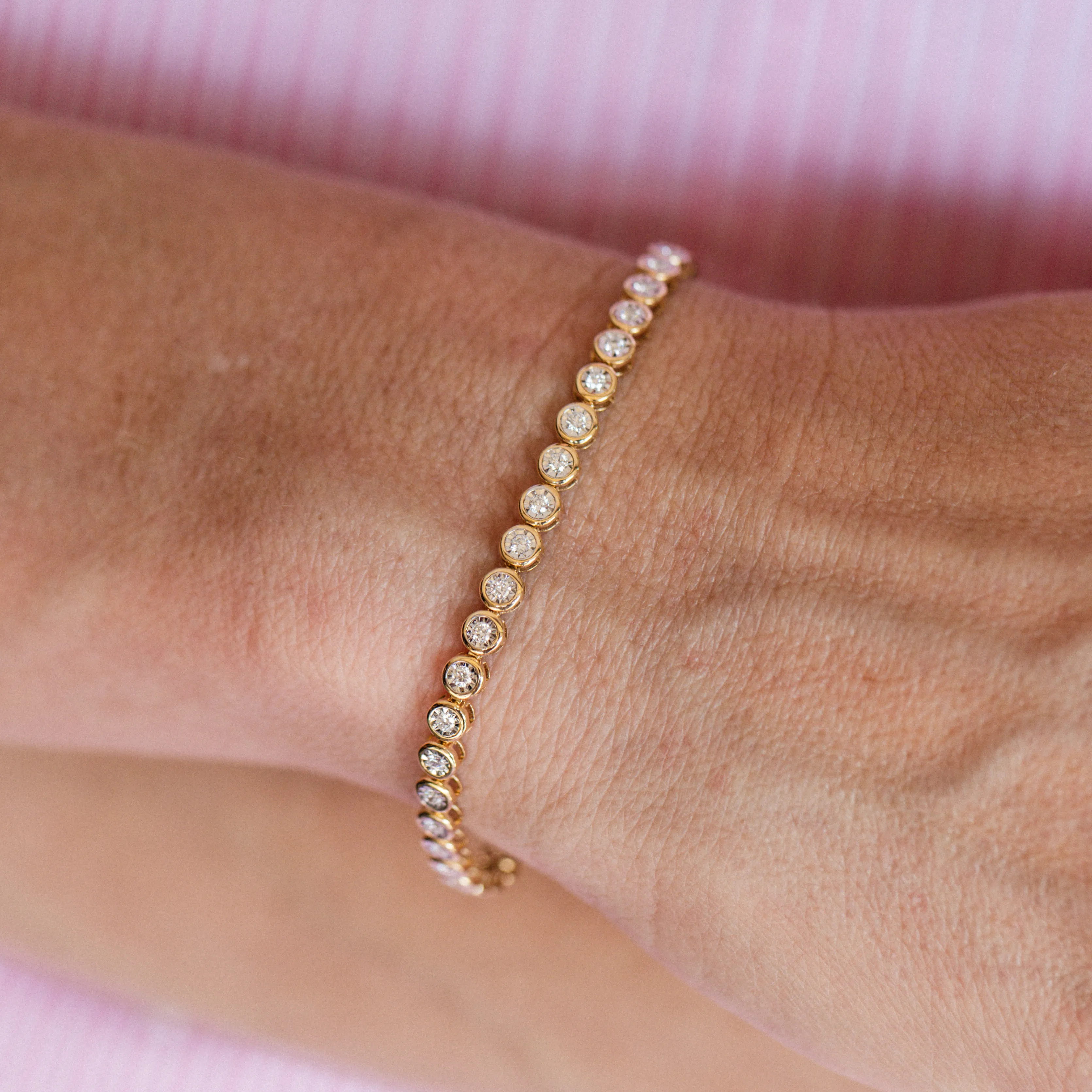 Elegant gold bracelet with diamonds on a wrist. Explore more bracelets.