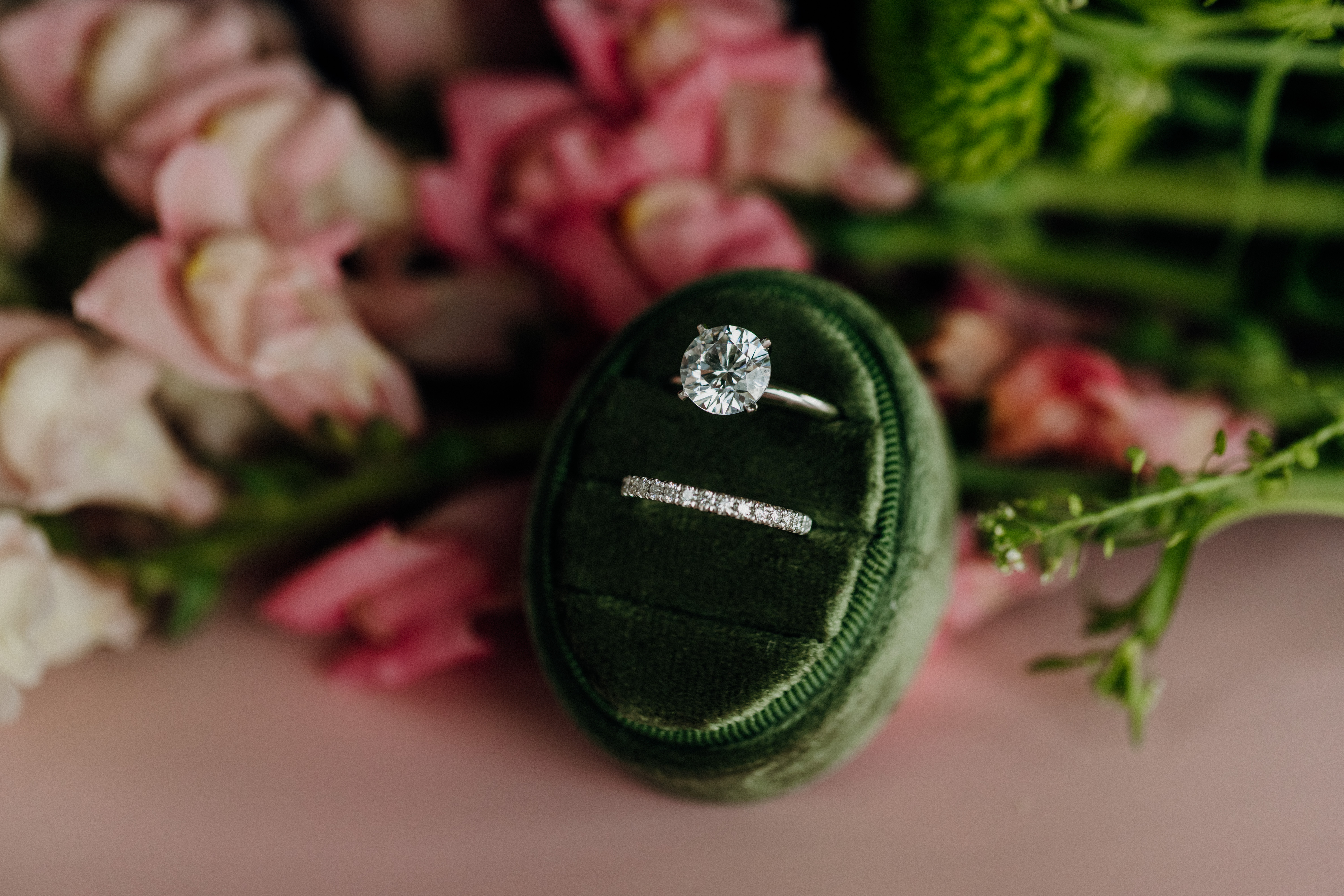Elegant engagement and wedding rings displayed on a soft velvet cushion.