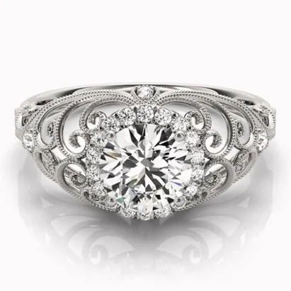 Vintage engagement ring with a large round diamond surrounded by intricate filigree and smaller diamonds.
