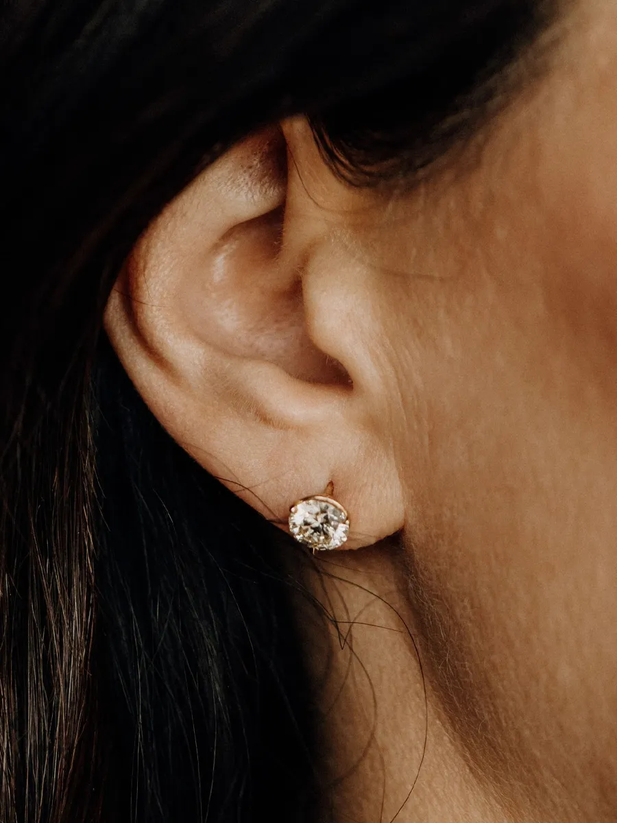 Close-up of a woman's ear with a sparkling diamond stud earring. Click to view Diamond Studs at Koerbers Fine Jewelry.