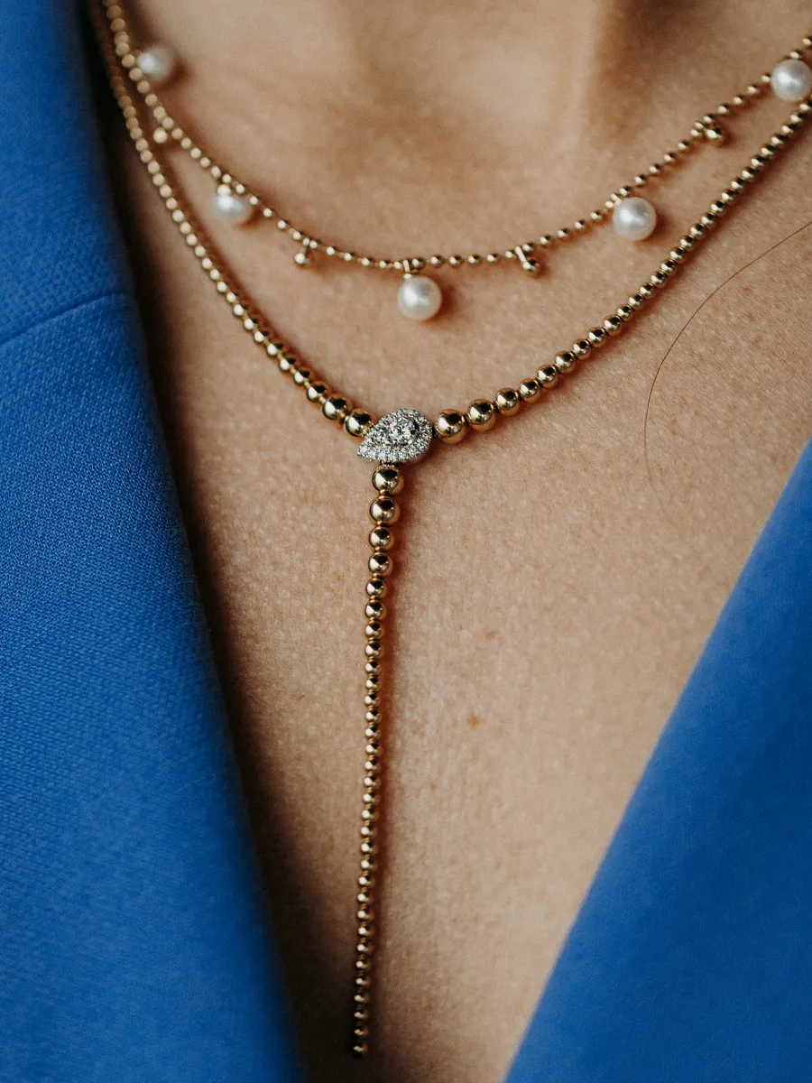 Elegant layered gold and pearl necklaces with a sparkling centerpiece, showcasing fine jewelry from Koerbers Fine Jewelry Inc.