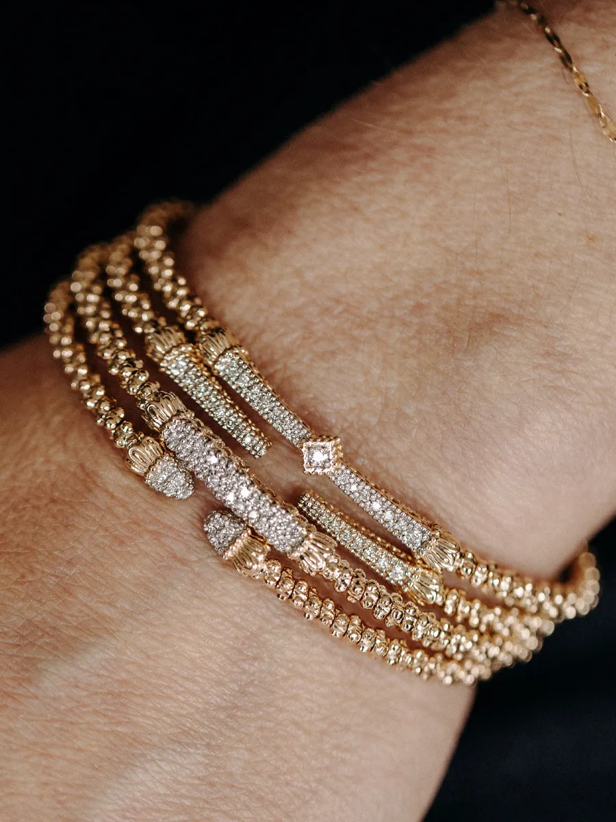 Elegant gold and diamond bracelets stacked on a wrist.
