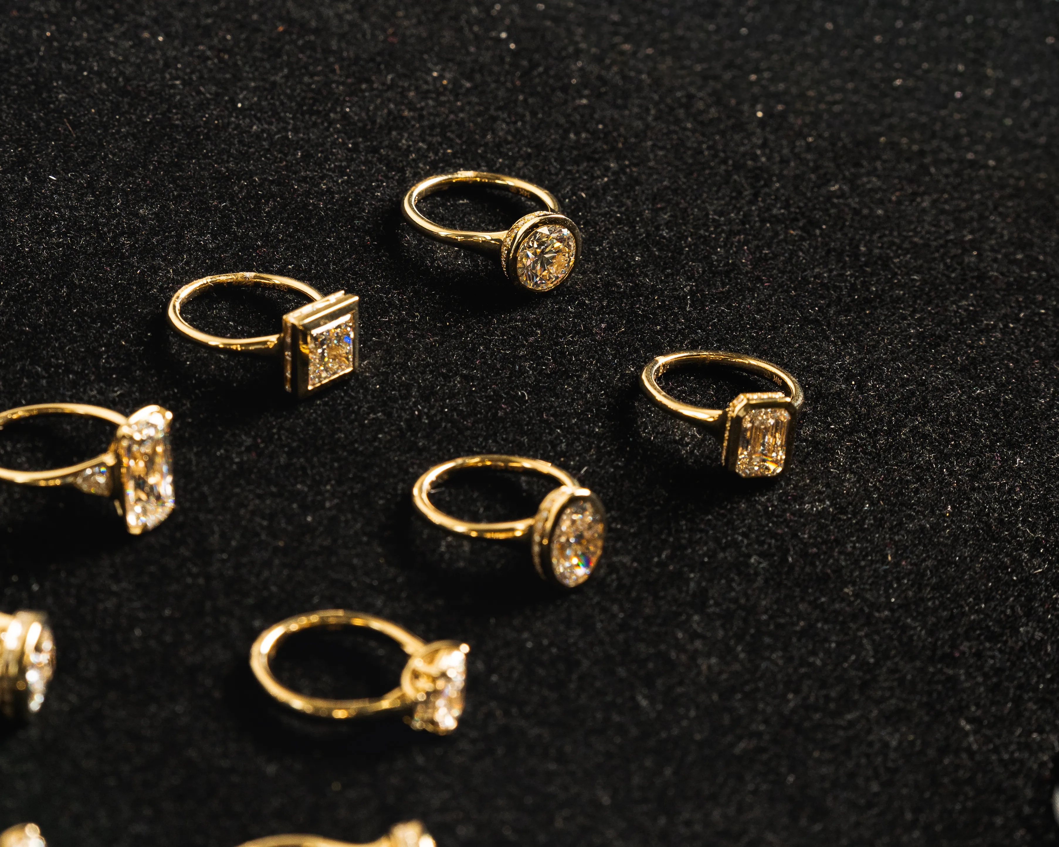 A hand with a diamond ring is held up against a blurred outdoor background. Schedule Consultation.