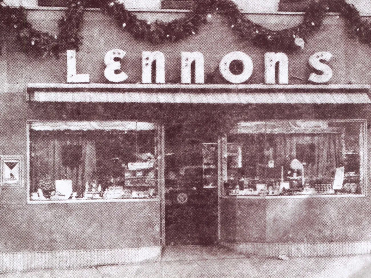 Vintage storefront of Lennon's W.B. Wilcox Jewelers with festive garlands.