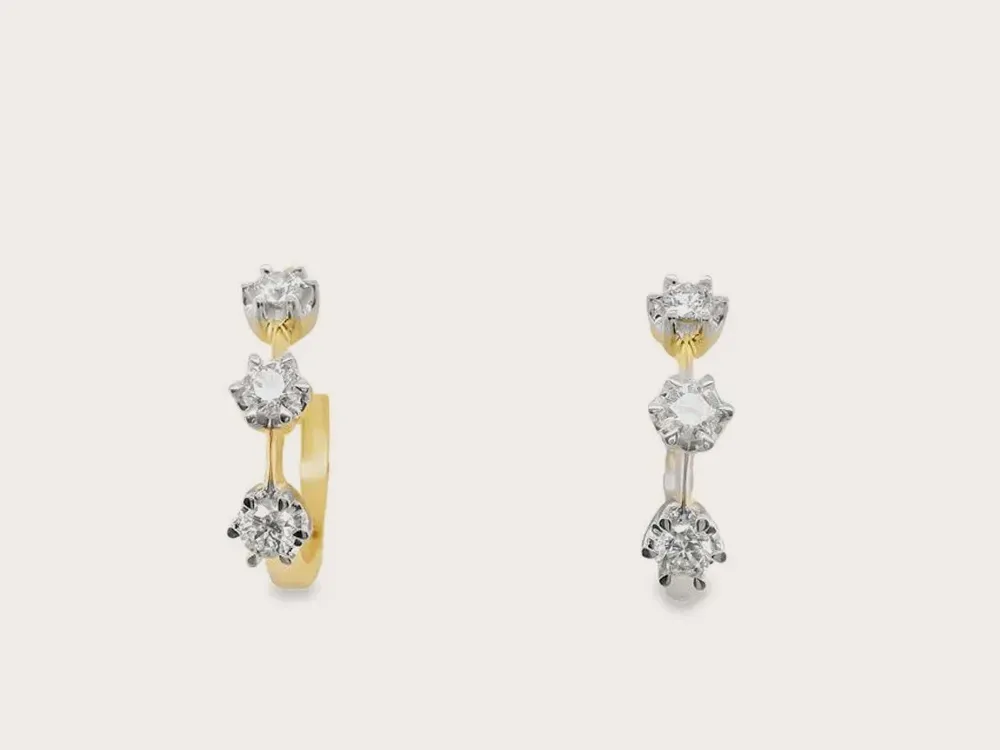Gold earrings with three diamond studs each, displayed on a white background. Click to view 