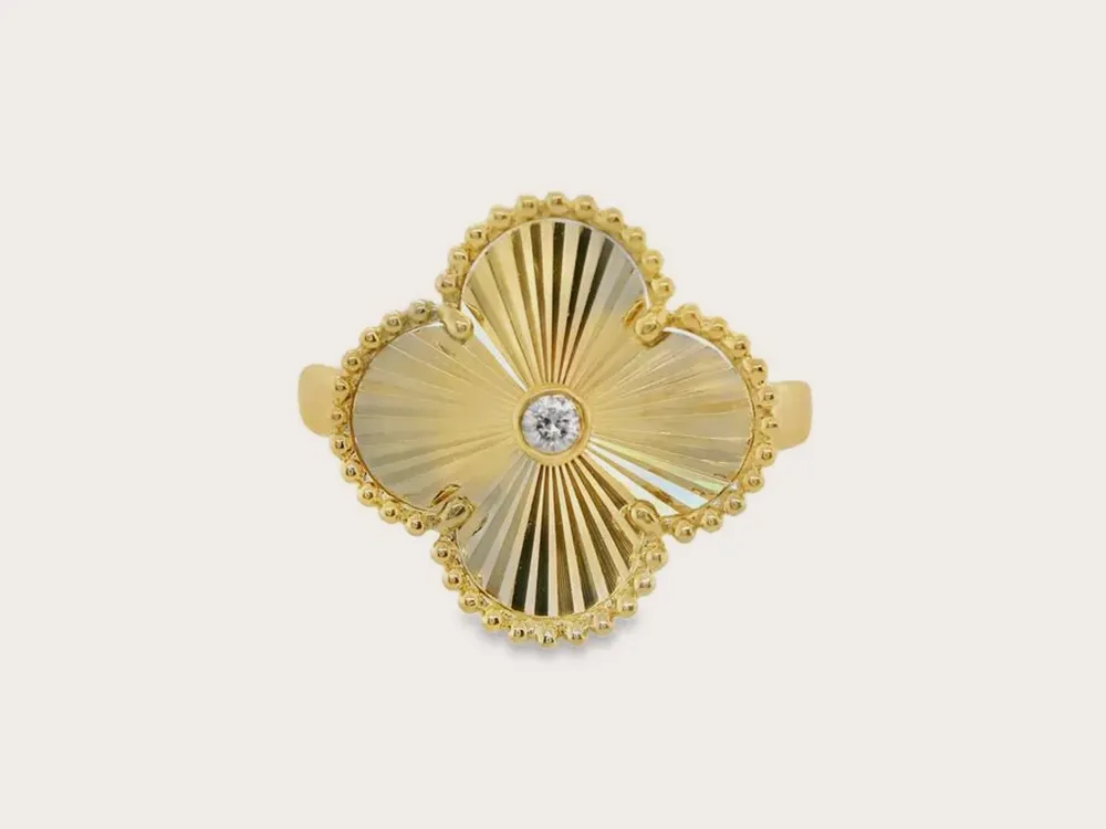 Gold clover-shaped ring with a central diamond. Explore fashion rings.