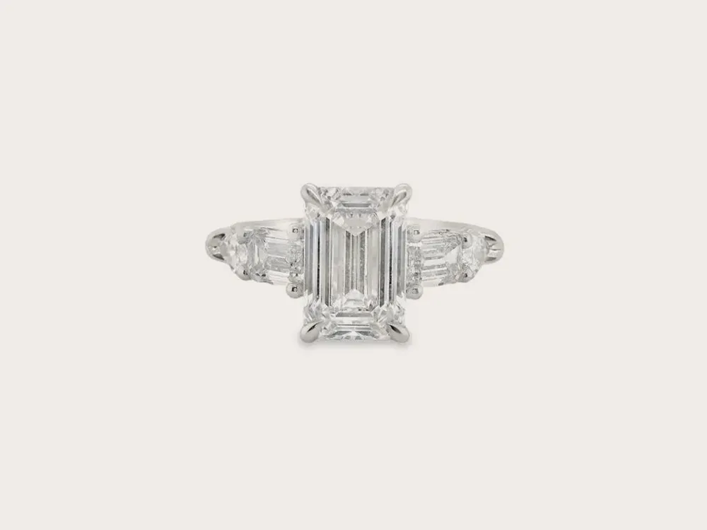 Emerald-cut diamond ring with side stones on a white background. Shop Lab Grown Jewelry.