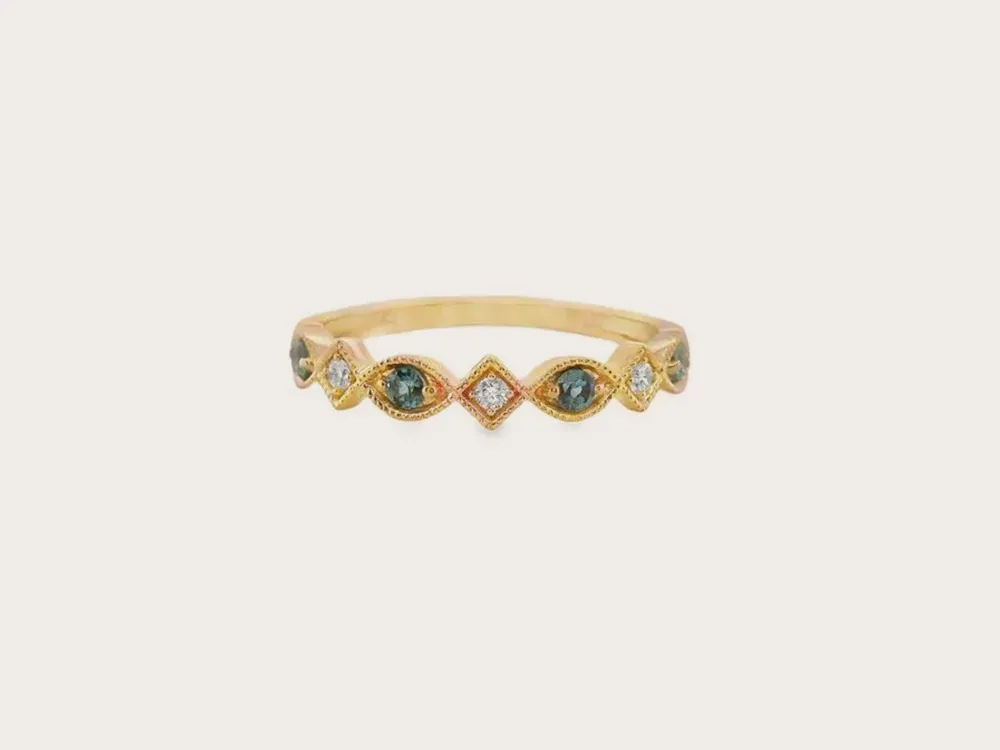 Gold ring with alternating blue and clear gemstones. Shop Fashion Rings.