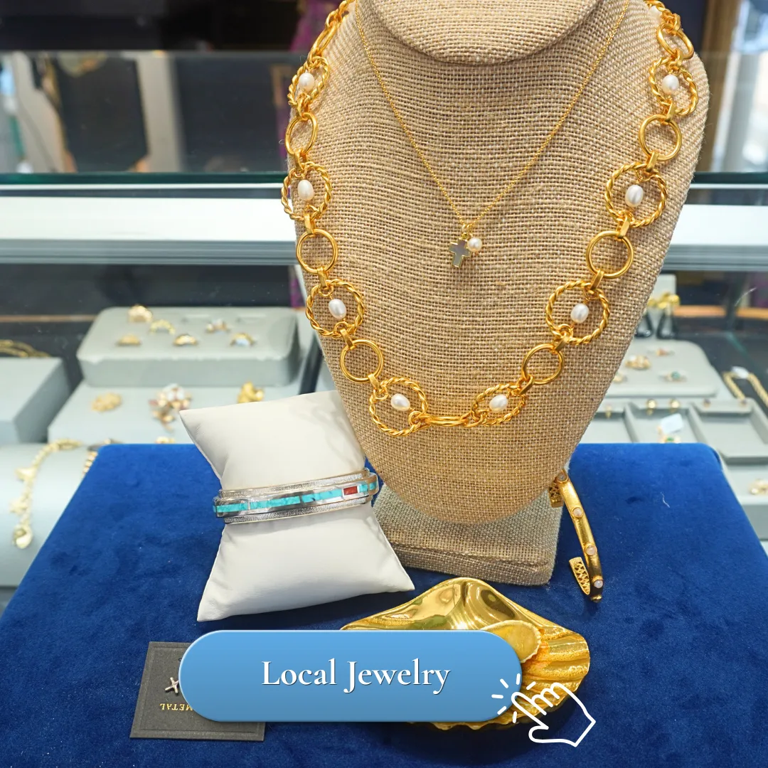 Elegant gold and pearl necklace, bracelet, and earrings displayed on a blue velvet surface.