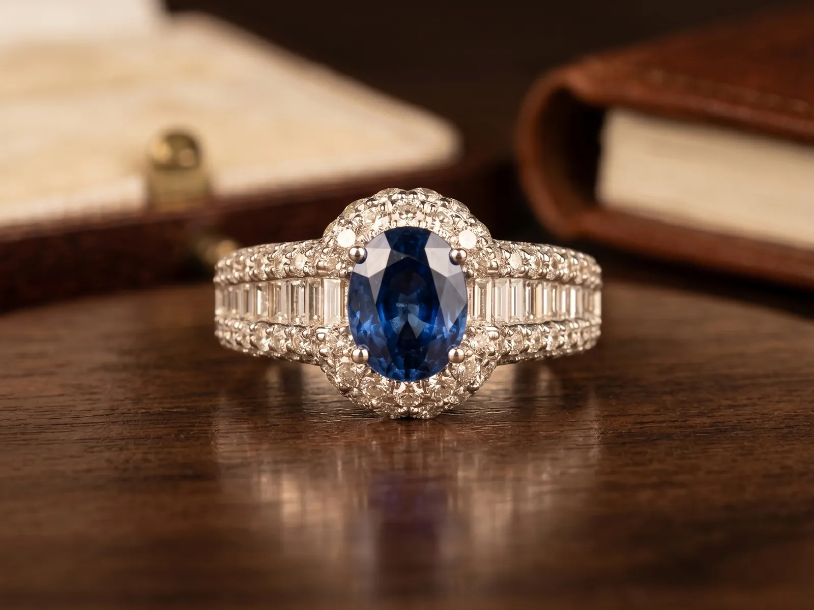 A sapphire and diamond ring displayed on a wooden surface.