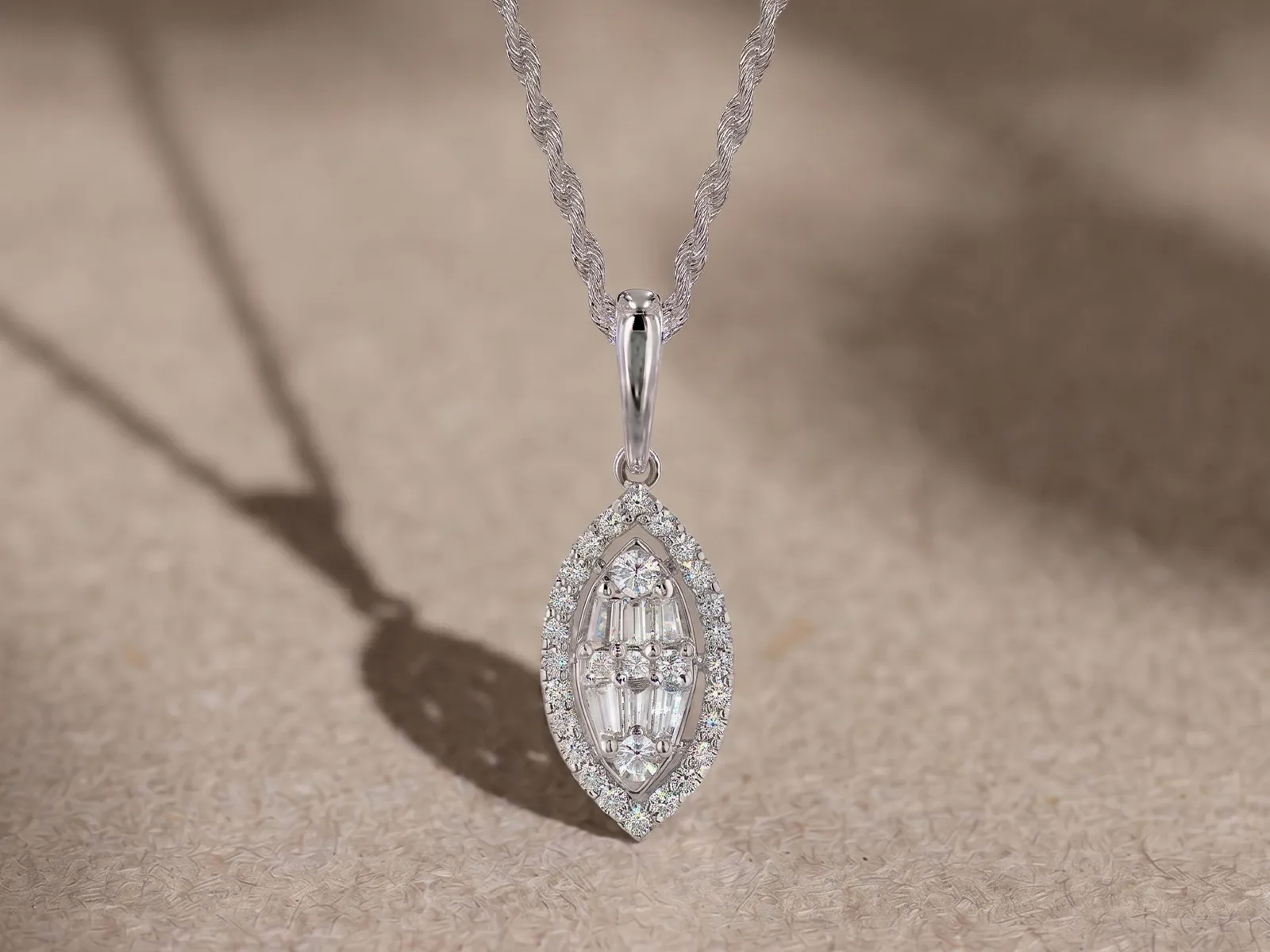 Elegant diamond pendant necklace on a textured surface at Marshall's Jewelers, Bellingham MA.