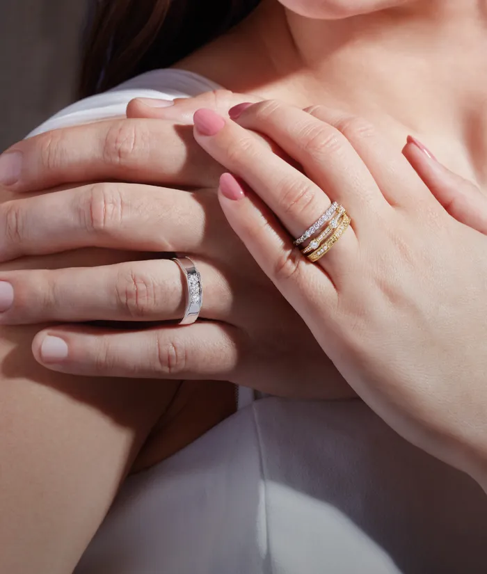 Couple embracing, showcasing elegant engagement and wedding rings.