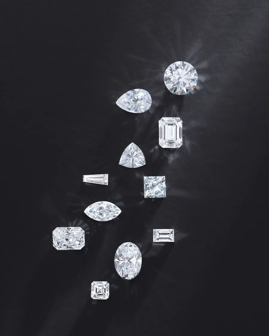 Various diamond shapes arranged on a dark background, showcasing the 4C's of diamonds.