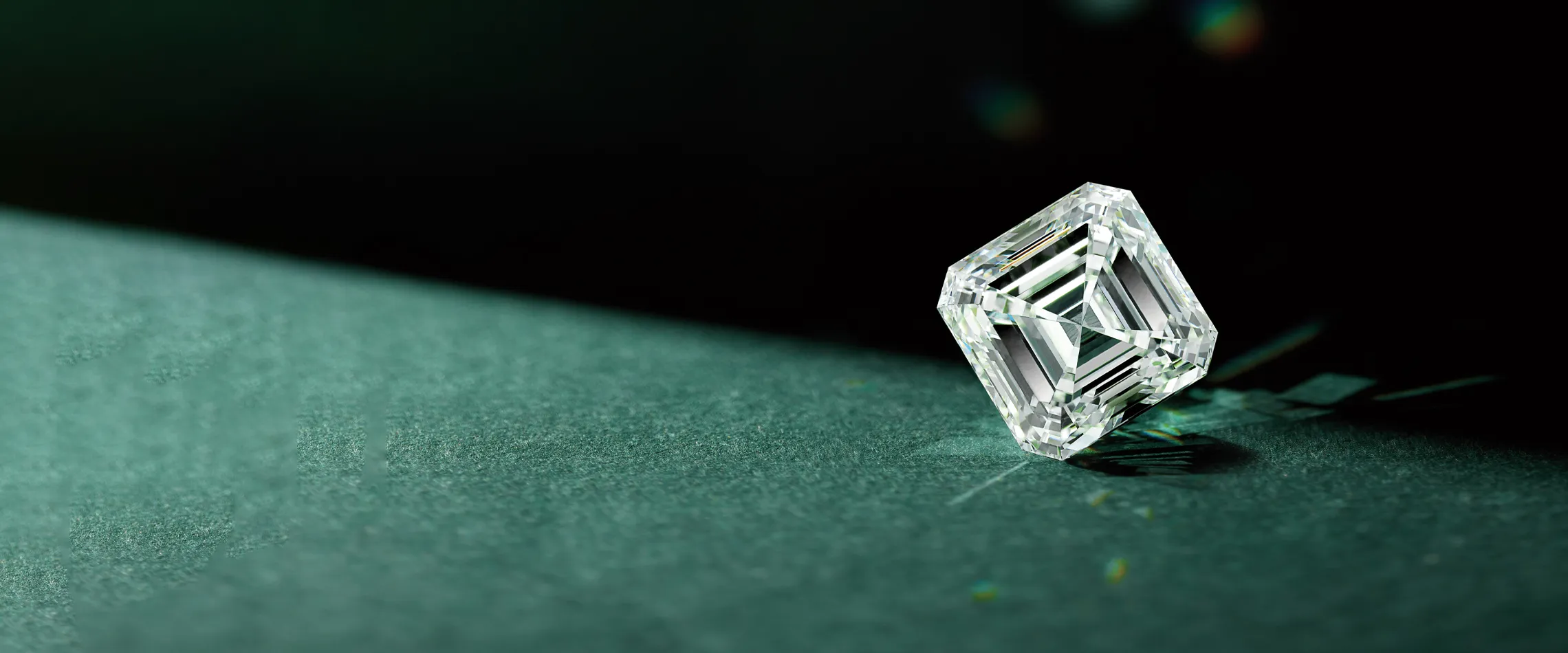 A sparkling diamond sits on a green surface, showcasing its brilliance and clarity. 