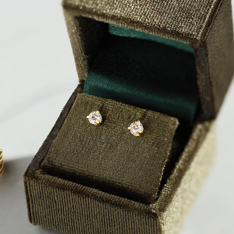 Gold diamond stud earrings in a velvet box, perfect for gifting.