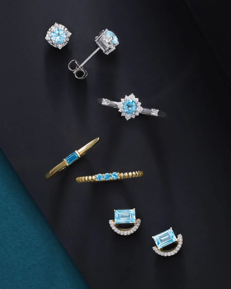 Collection of elegant blue gemstone jewelry including earrings, rings, and bracelets.