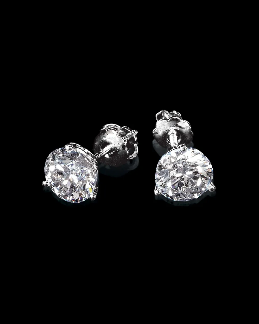 Sparkling diamond stud earrings on a black background.