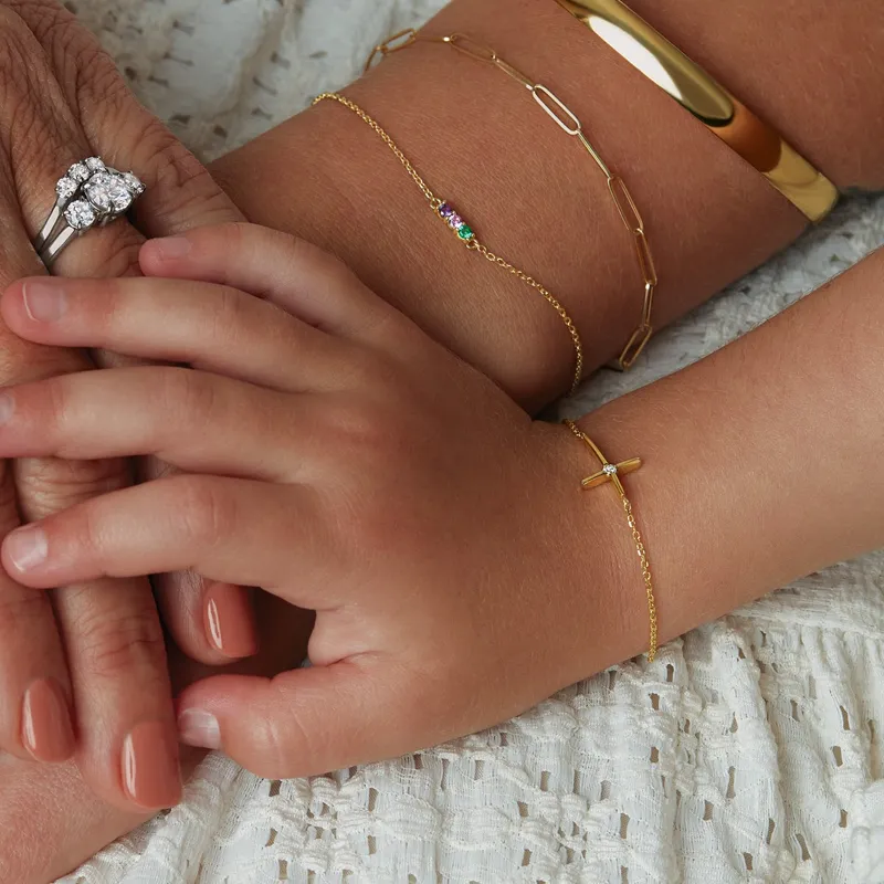 A close-up of hands wearing various jewelry pieces, showcasing rings and bracelets, symbolizing connection and love.