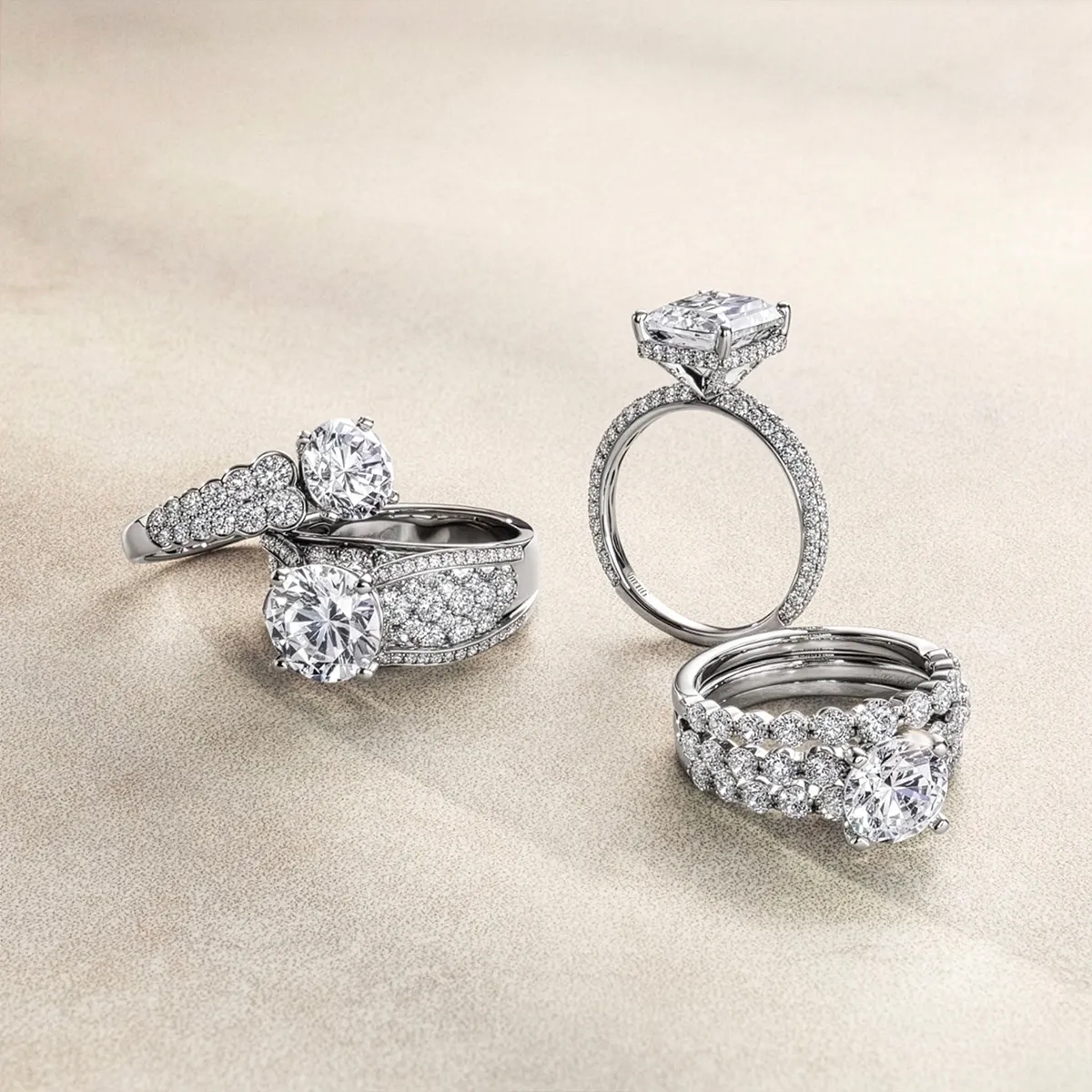 Elegant diamond engagement rings displayed on a neutral background.