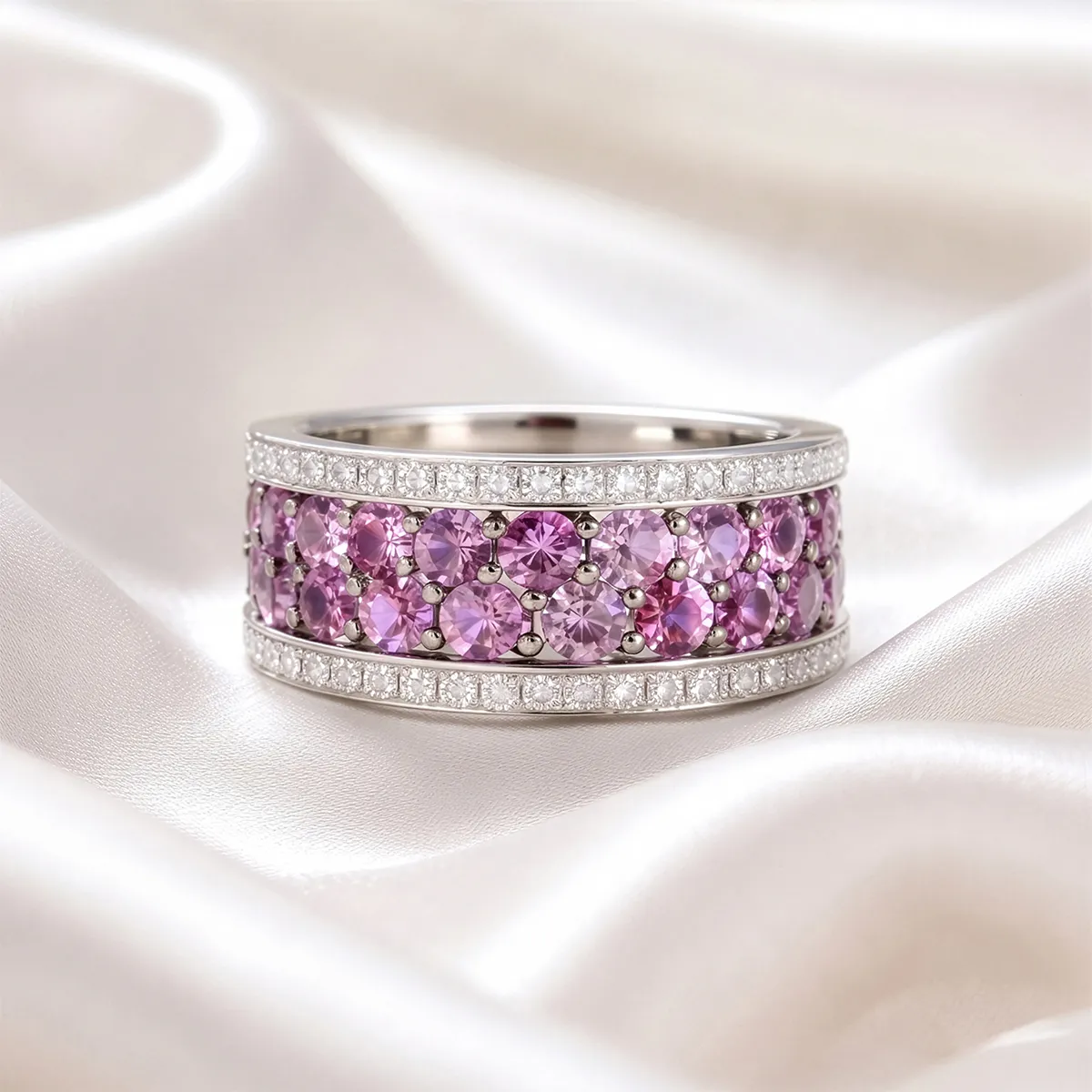 Elegant ring with pink and white gemstones on silky fabric background.