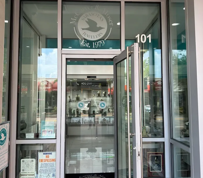 Entrance to McCarver Moser jewelry store with glass doors and display cases inside.